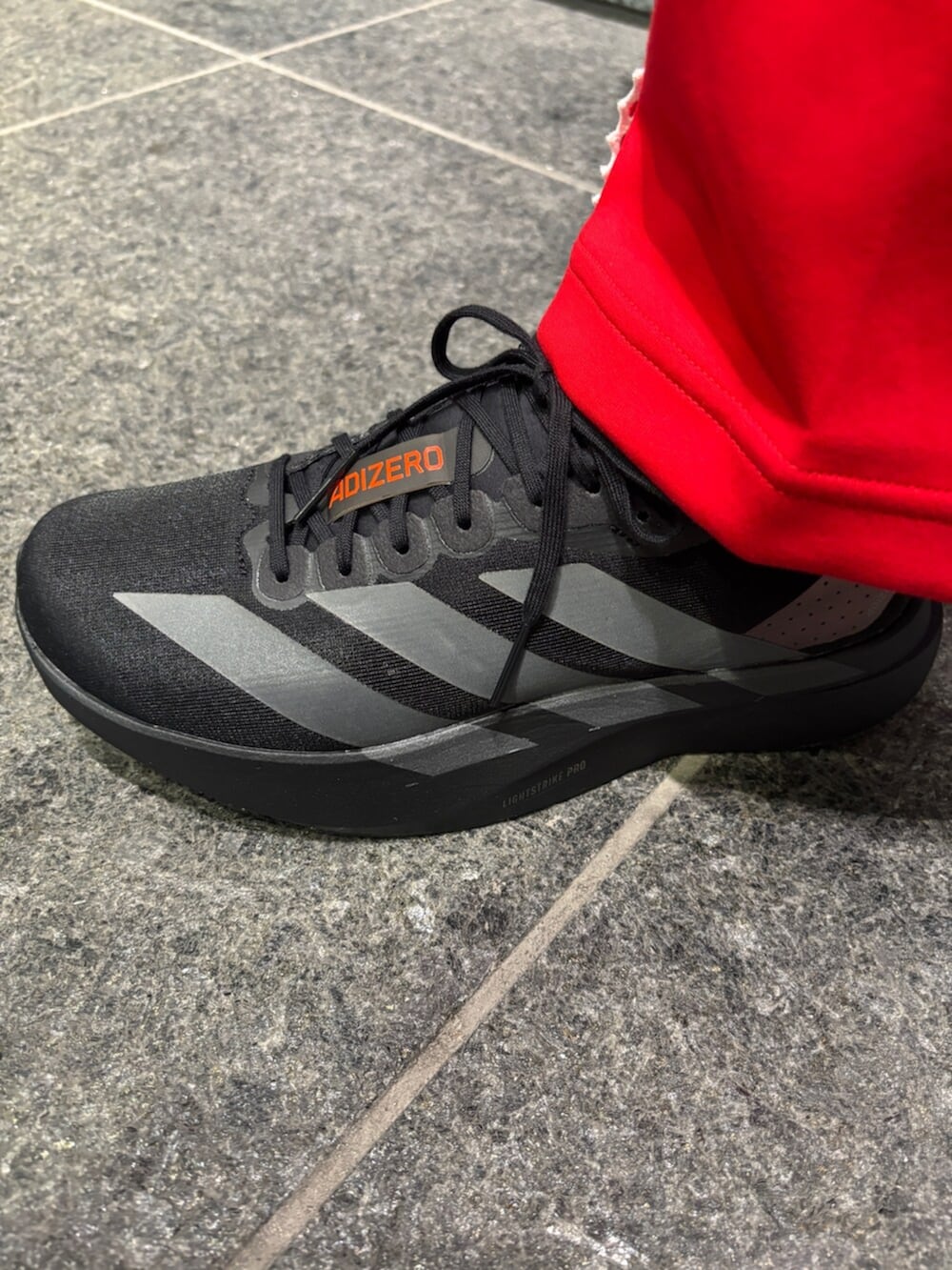 レッド系のトップス、ホワイト系のトップス、レッド系のパンツを着用したメンズの冬コーディネートの6枚目の写真