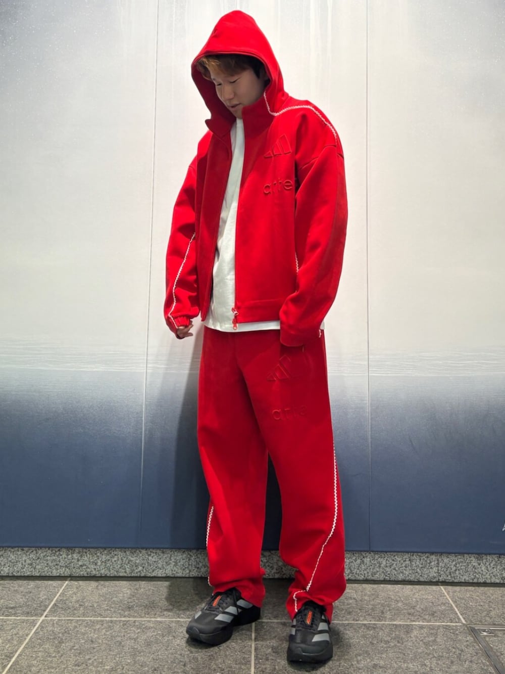 レッド系のトップス、ホワイト系のトップス、レッド系のパンツを着用したメンズの冬コーディネートの2枚目の写真