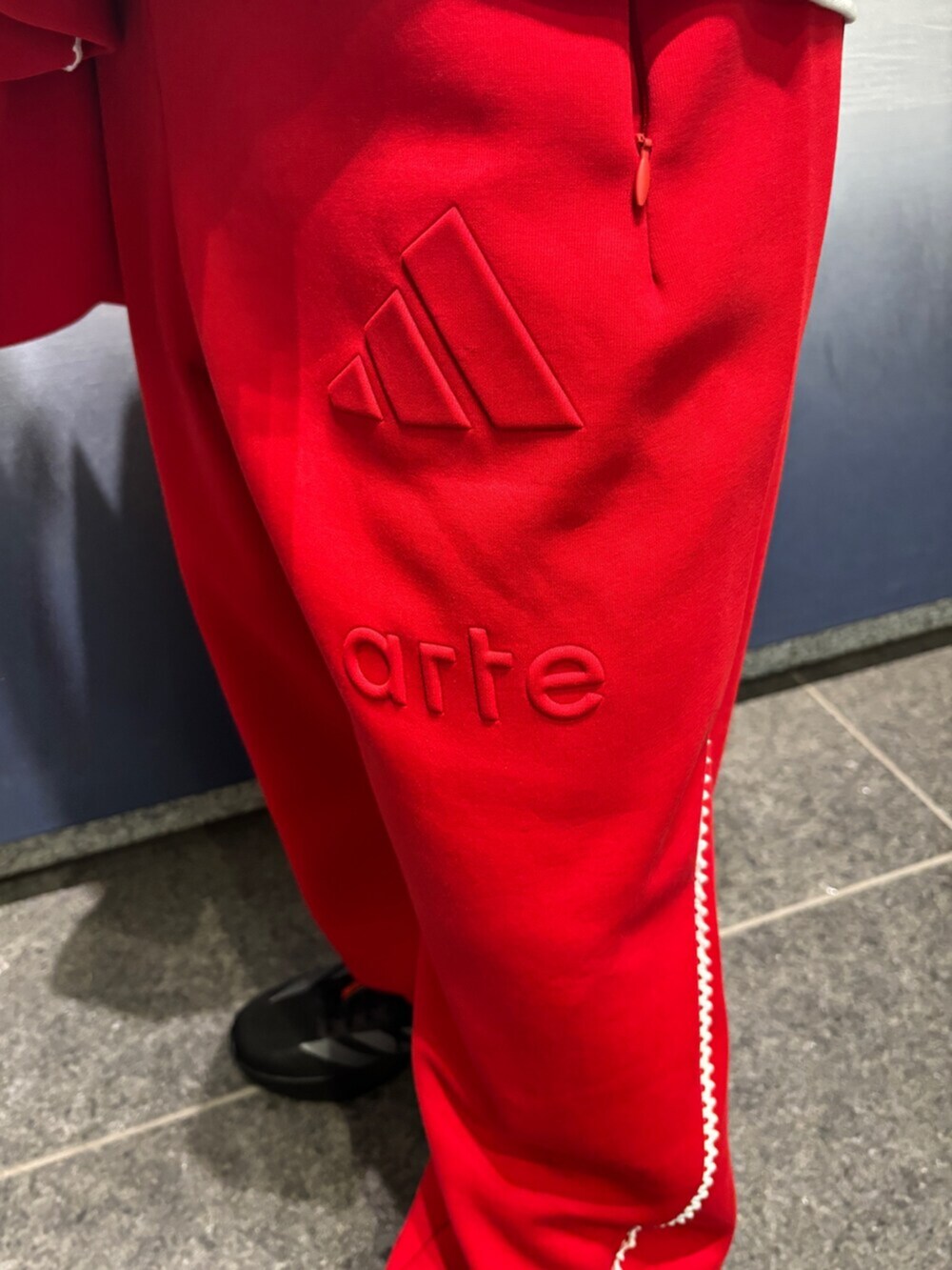 レッド系のトップス、ホワイト系のトップス、レッド系のパンツを着用したメンズの冬コーディネートの5枚目の写真