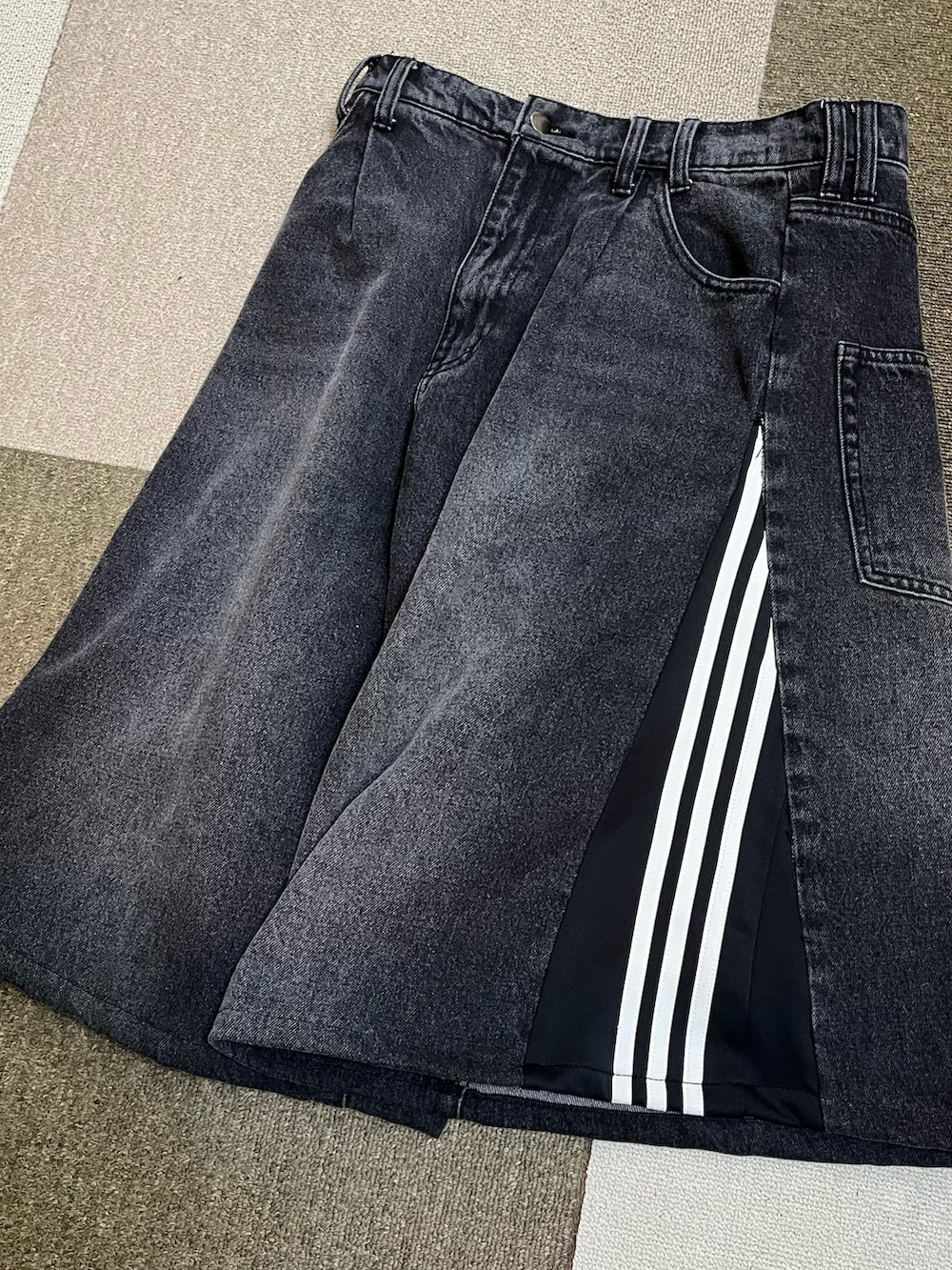 ベージュ系のスニーカー、ブラック系のデニムパンツ、ブラック系のスタジャンを着用したメンズの秋コーディネートの5枚目の写真