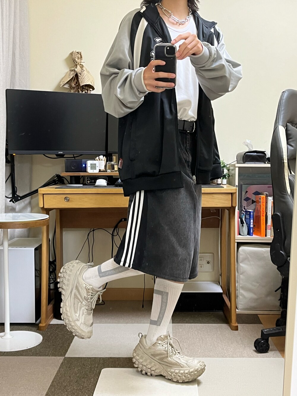 ベージュ系のスニーカー、ブラック系のデニムパンツ、ブラック系のスタジャンを着用したメンズの秋コーディネートの2枚目の写真