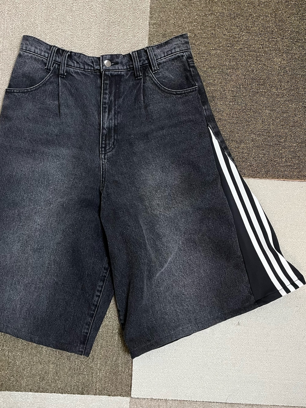 ベージュ系のスニーカー、ブラック系のデニムパンツ、ブラック系のスタジャンを着用したメンズの秋コーディネートの4枚目の写真