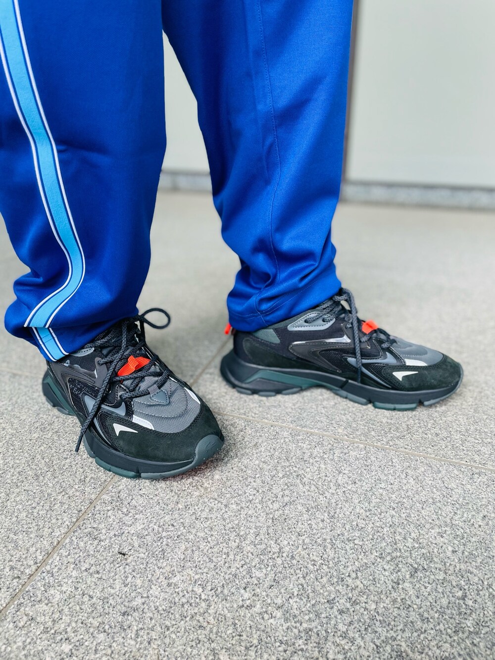 ブラウン系のスウェット、パープル系のチノパンツ、ブラック系のスニーカーを着用したメンズの秋コーディネートの5枚目の写真