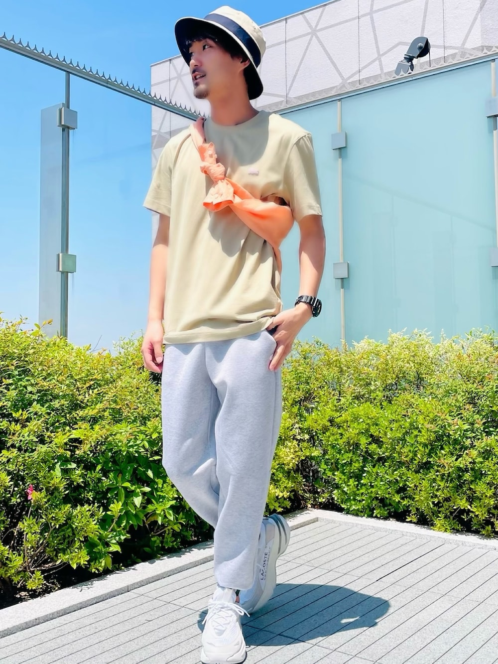 オレンジ系のシャツ/ブラウス、ベージュ系のTシャツ/カットソー、ホワイト系のスニーカーを着用したメンズの夏コーディネートの2枚目の写真