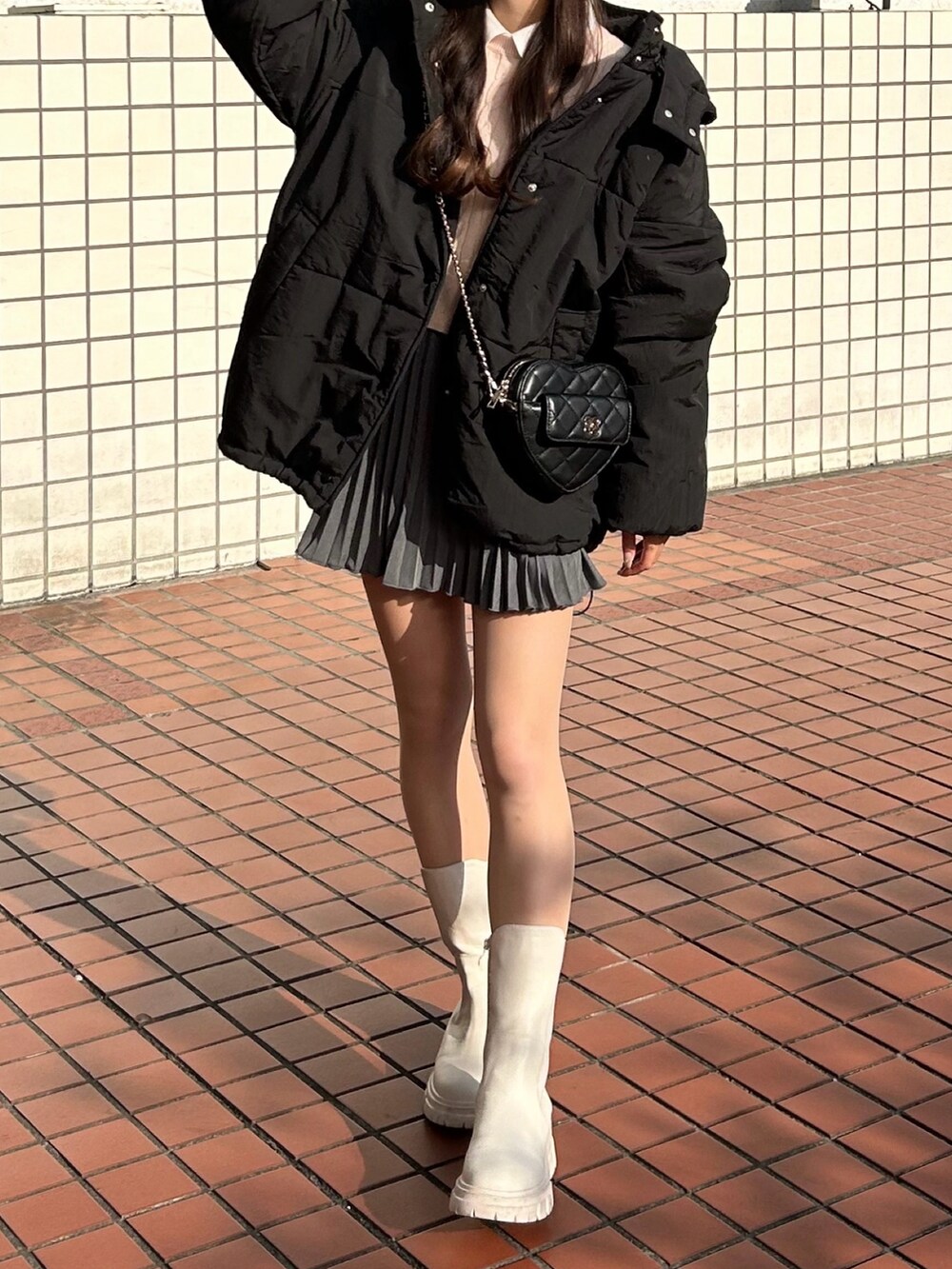 ピンク系のニット/セーター、ホワイト系のシャツ/ブラウス、ブラック系のショルダーバッグを着用したレディースの冬コーディネートの2枚目の写真