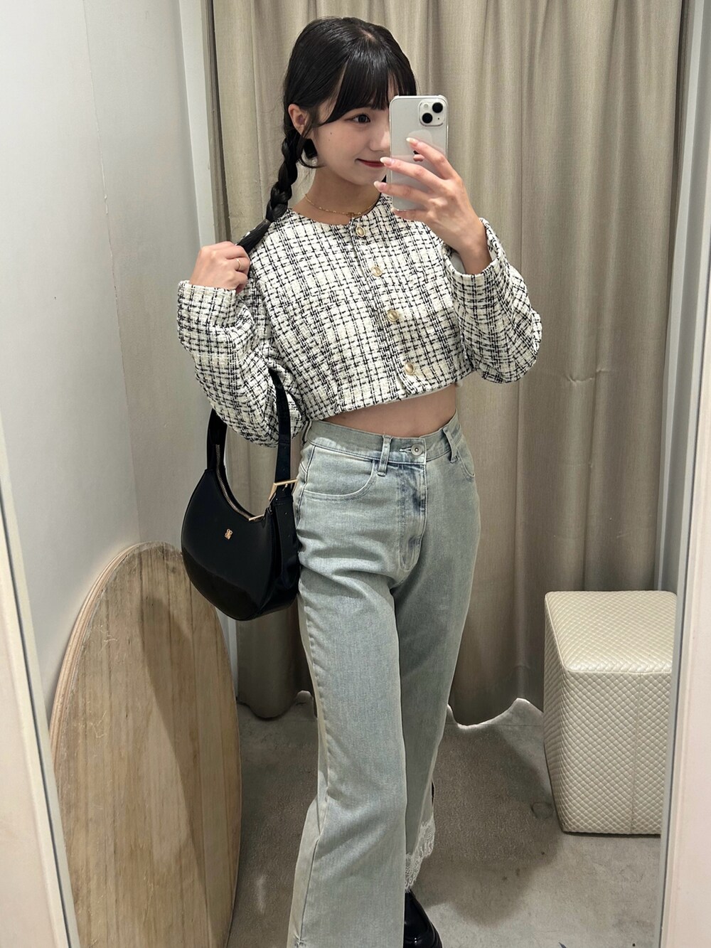 ホワイト系のノーカラージャケット、ブルー系のデニムパンツ、ブラック系のショルダーバッグを着用したレディースの秋コーディネートの2枚目の写真