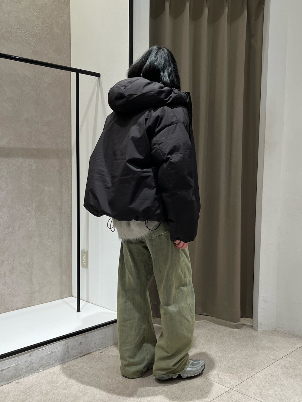 グレー系のカーディガン/ボレロ、グリーン系のデニムパンツ、ブラック系のダウンジャケット/コートを着用したメンズの冬コーディネートの2枚目の写真