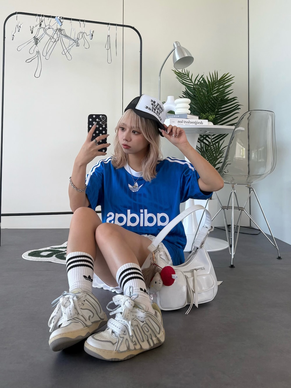 ブルー系のTシャツ/カットソー、ホワイト系のスニーカー、ホワイト系のショルダーバッグを着用したレディースの夏コーディネートの2枚目の写真