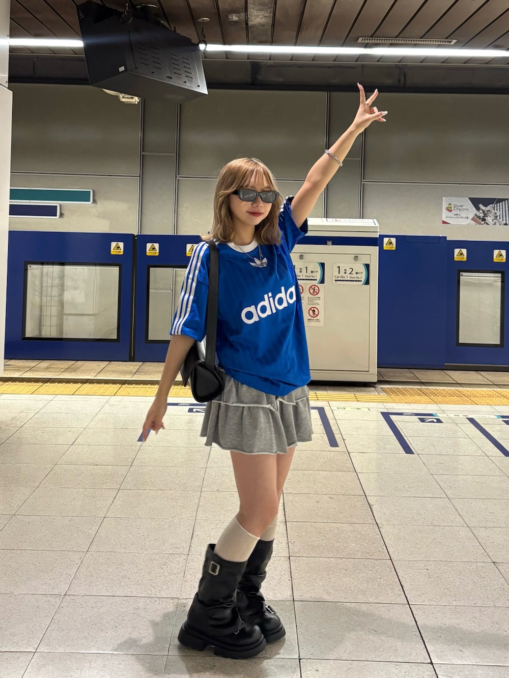 ブルー系のTシャツ/カットソー、ブラック系のブーツ、グレー系のスカートを着用したレディースの春コーディネートの2枚目の写真