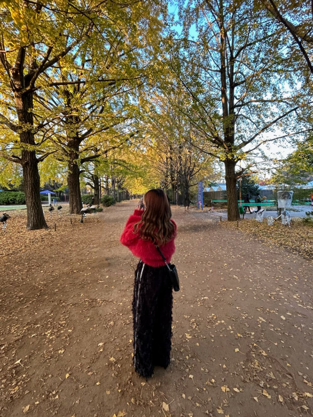 ブラック系のその他パンツ、レッド系のニット/セーター、ピンク系のストール/ショールを着用したレディースの冬コーディネートの2枚目の写真