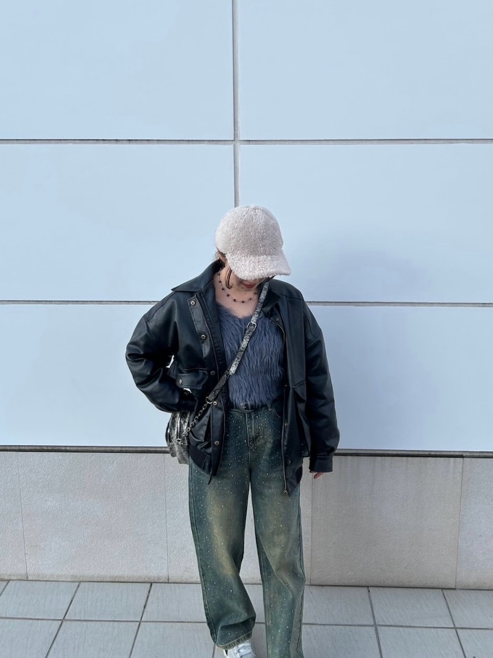 グレー系のニット/セーター、ブラック系のブルゾン、ブルー系のデニムパンツを着用したレディースの冬コーディネートの2枚目の写真