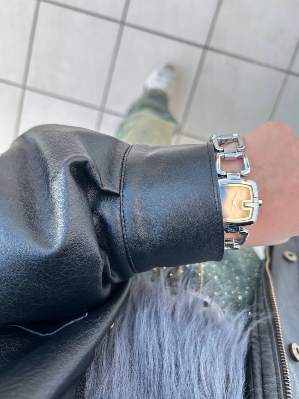 グレー系のニット/セーター、ブラック系のブルゾン、ブルー系のデニムパンツを着用したレディースの冬コーディネートの3枚目の写真