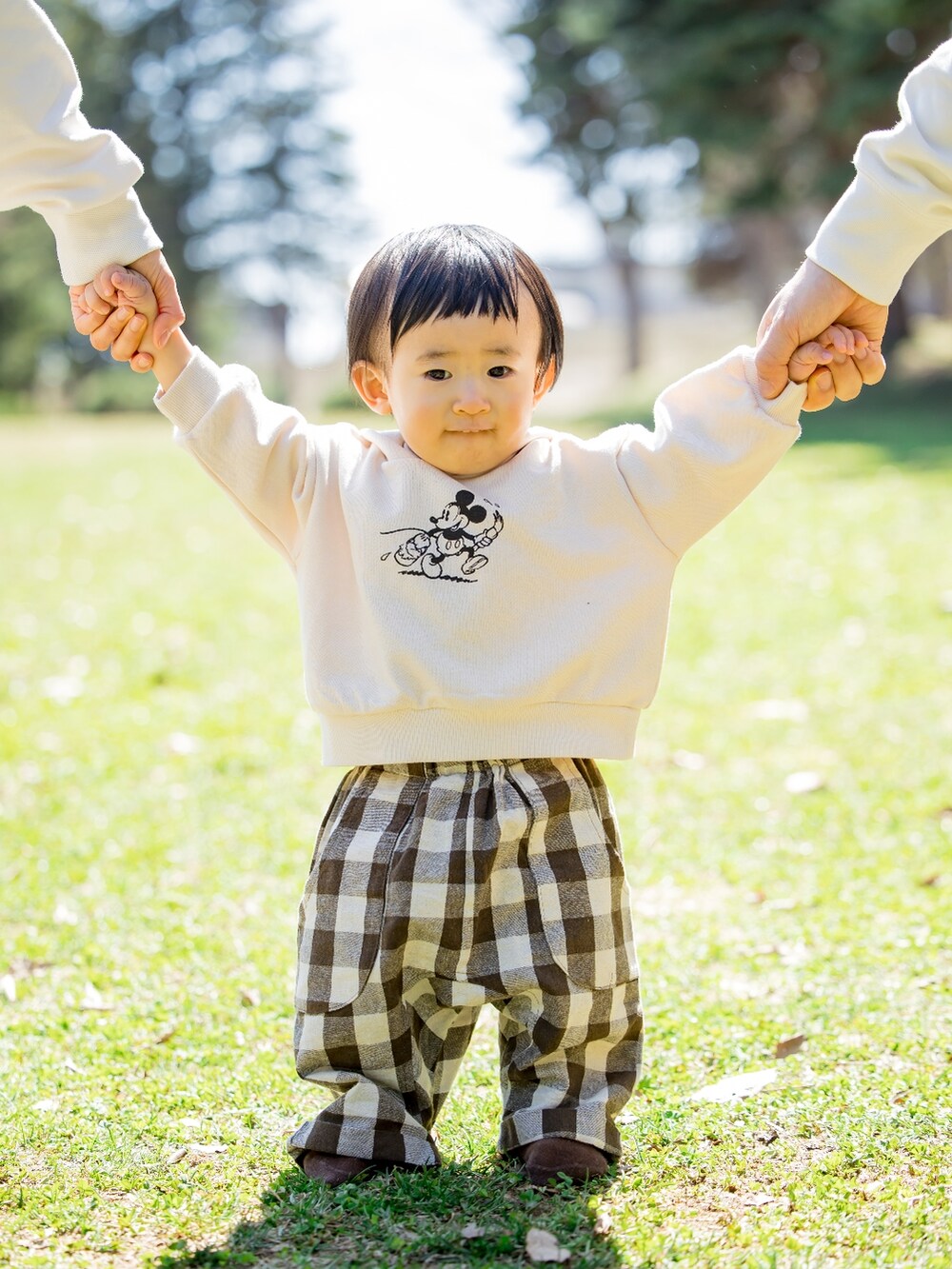 ホワイト系のパーカー、ブラウン系のパンツを着用したキッズの秋コーディネートの2枚目の写真