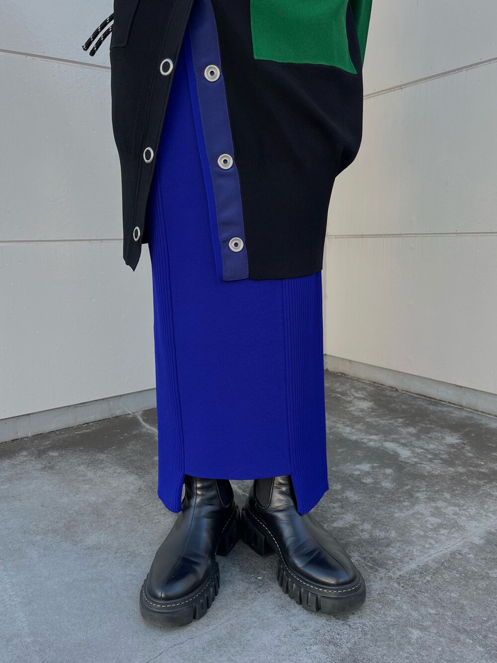 ブラック系のニット/セーター、ブラック系のカーディガン/ボレロ、ブルー系のスカートを着用したレディースの冬コーディネートの8枚目の写真