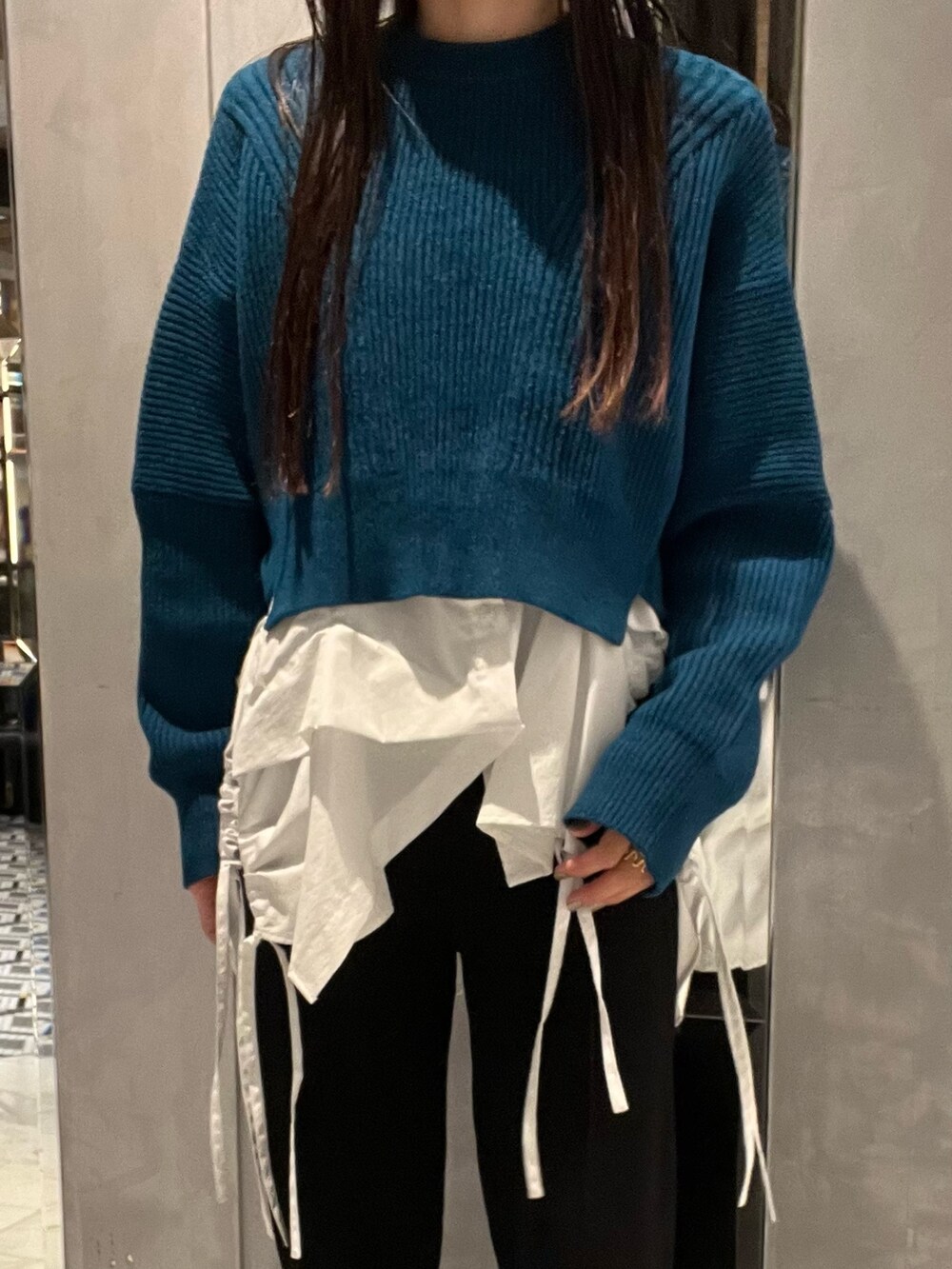 ブラック系のその他パンツ、ホワイト系のキャミソール、ブルー系のニット/セーターを着用したレディースの冬コーディネートの3枚目の写真