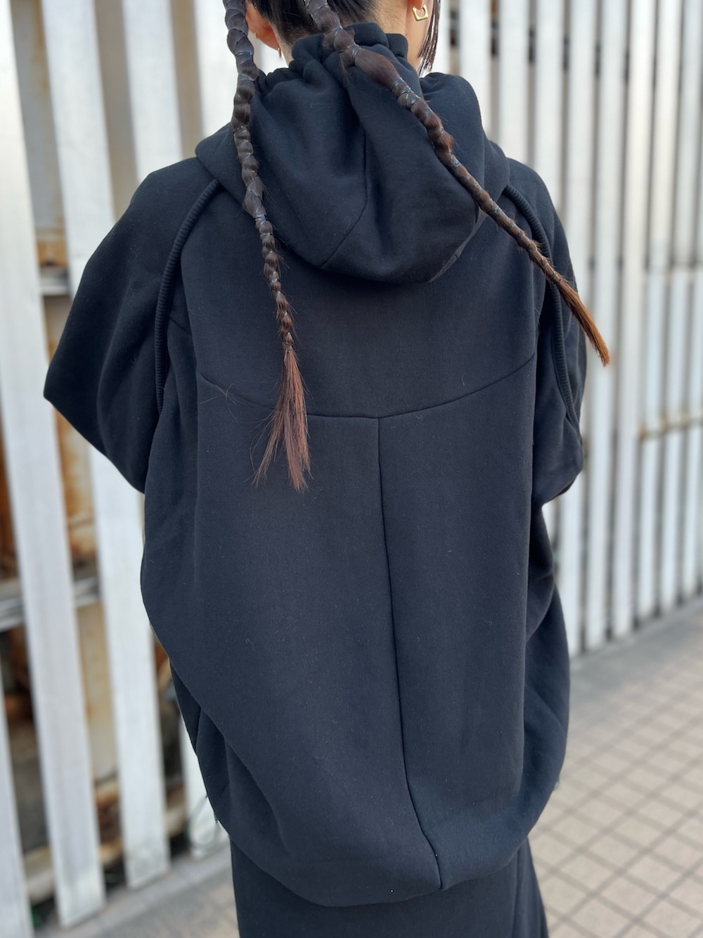 ブラック系のパーカー、ブラック系のスカート、ブラック系のブーツを着用したレディースの冬コーディネートの7枚目の写真