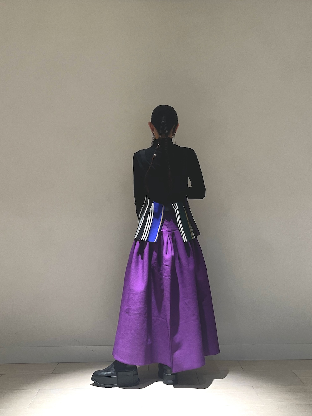 ブラック系のキャミソール、パープル系のスカート、ブラック系のブーツを着用したレディースの冬コーディネートの3枚目の写真