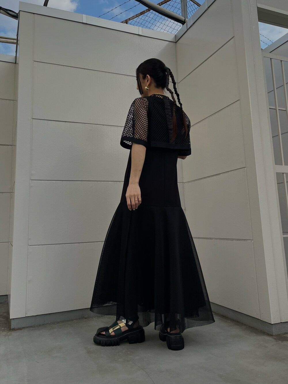 ブラック系のワンピース、その他のサンダル、ゴールド系のネックレスを着用したレディースの春コーディネートの4枚目の写真