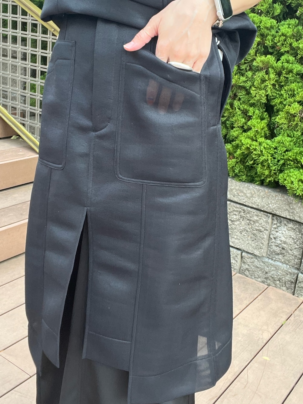 ブラック系のTシャツ/カットソー、ブラック系のスカート、ブラック系のサンダルを着用したレディースの春コーディネートの5枚目の写真