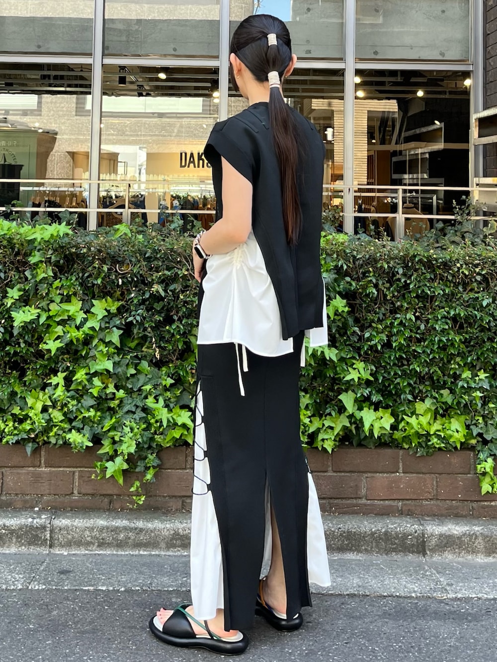 ブラック系のニット/セーター、ブラック系のスカート、その他のサンダルを着用したレディースの春コーディネートの2枚目の写真