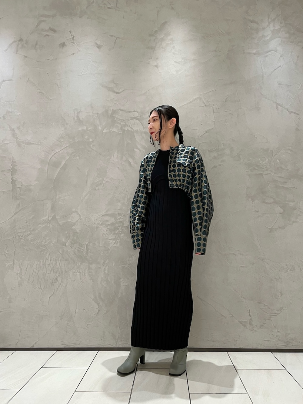 グリーン系のブルゾン、ブラック系のワンピース、ベージュ系のブーツを着用したレディースの冬コーディネートの2枚目の写真