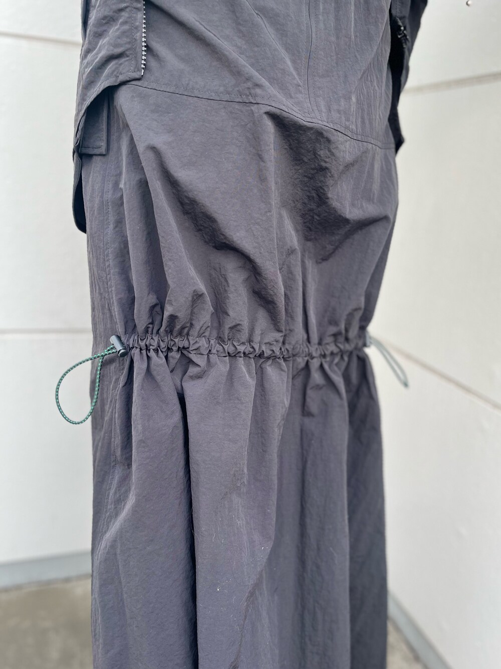 ブラック系のマウンテンパーカー、ブラック系のスカートを着用したレディースの夏コーディネートの10枚目の写真