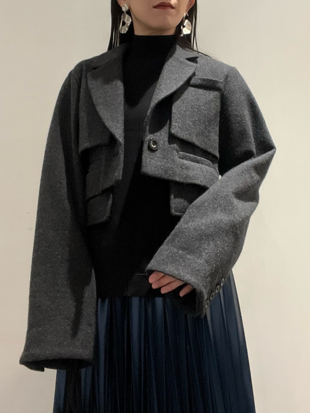 ブルー系のスカート、ブラック系のブーツ、その他のショルダーバッグを着用したレディースの秋コーディネートの3枚目の写真