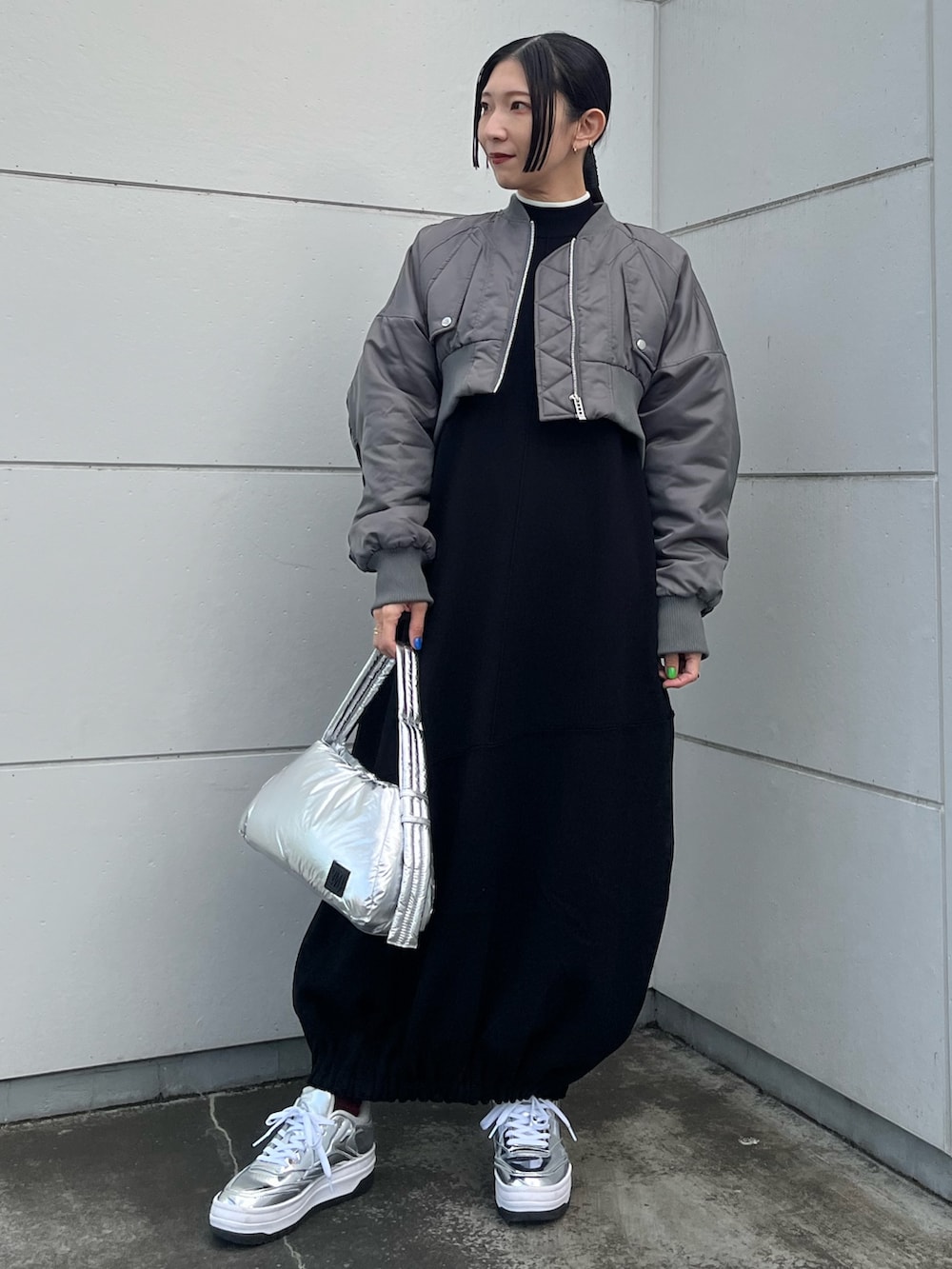 ブラック系のワンピース、グレー系のMA-1、シルバー系のハンドバッグを着用したレディースの冬コーディネートの2枚目の写真