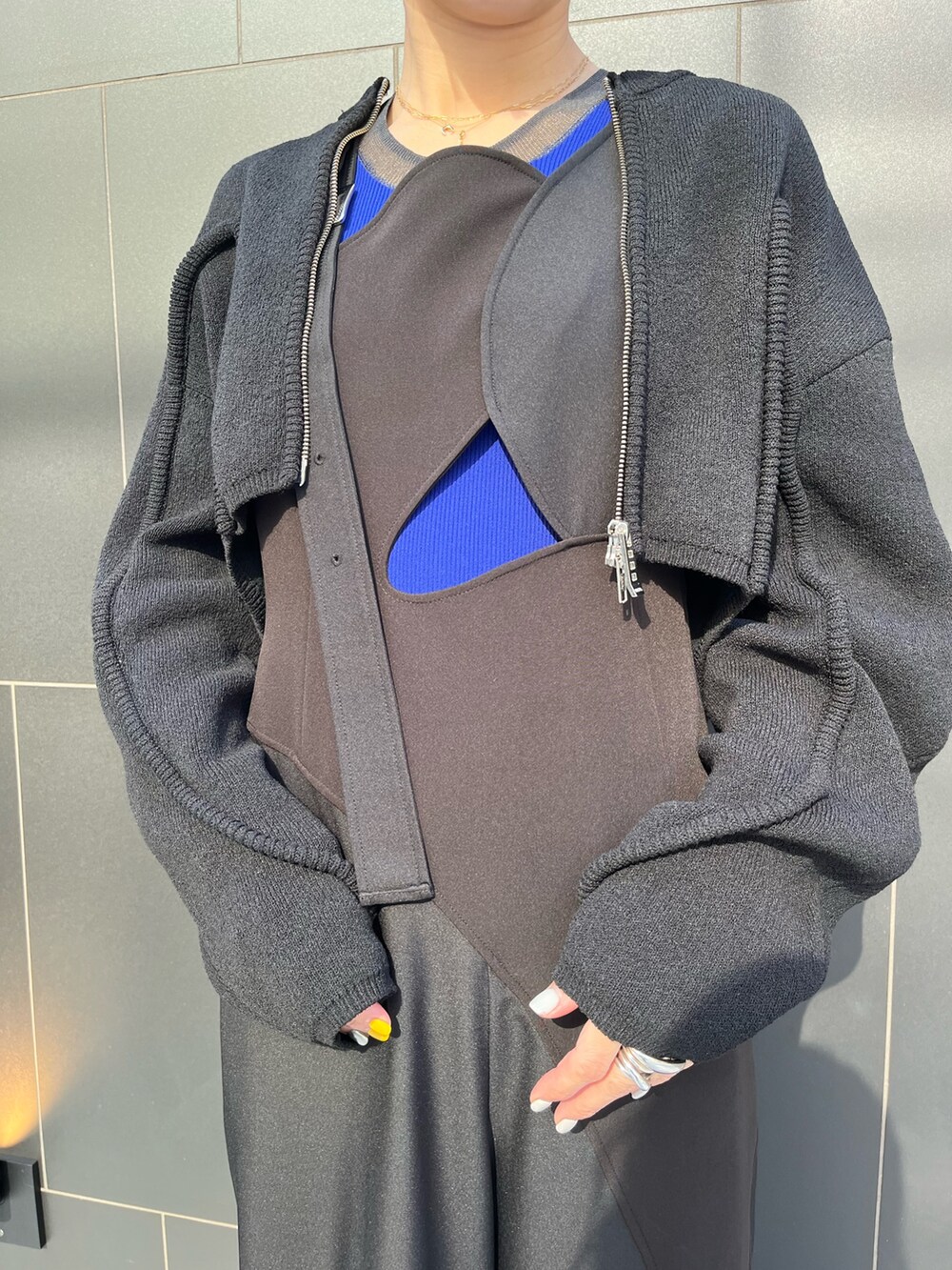 ブラック系のつなぎ/オールインワン、ブラック系のカーディガン/ボレロ、ブラック系のブーツを着用したレディースの冬コーディネートの5枚目の写真