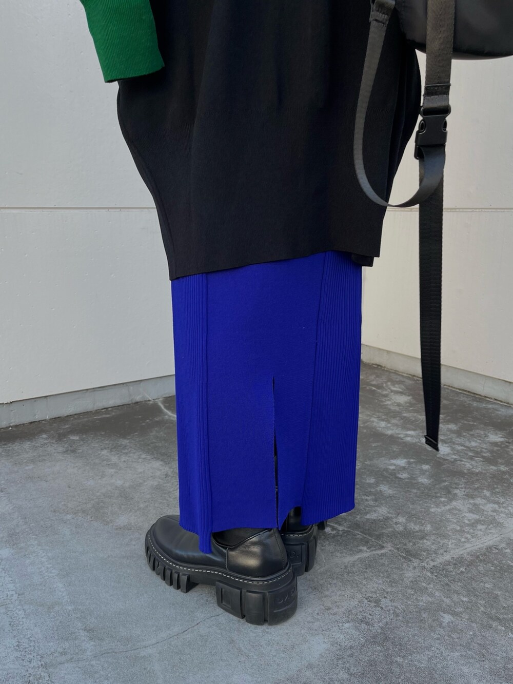 ブラック系のニット/セーター、ブラック系のカーディガン/ボレロ、ブルー系のスカートを着用したレディースの冬コーディネートの9枚目の写真