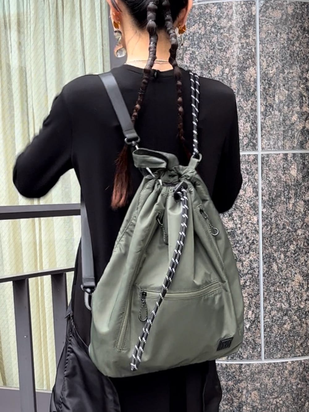 ブラック系のブーツ、ブラック系のワンピース、グリーン系のショルダーバッグを着用したレディースの秋コーディネートの7枚目の写真