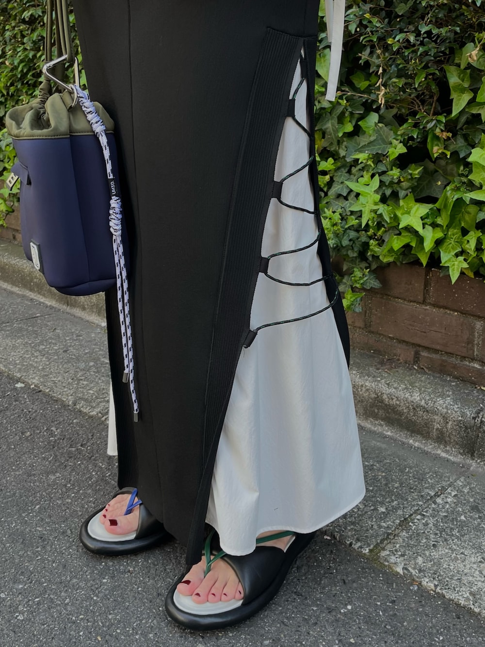 ブラック系のニット/セーター、ブラック系のスカート、その他のサンダルを着用したレディースの春コーディネートの6枚目の写真