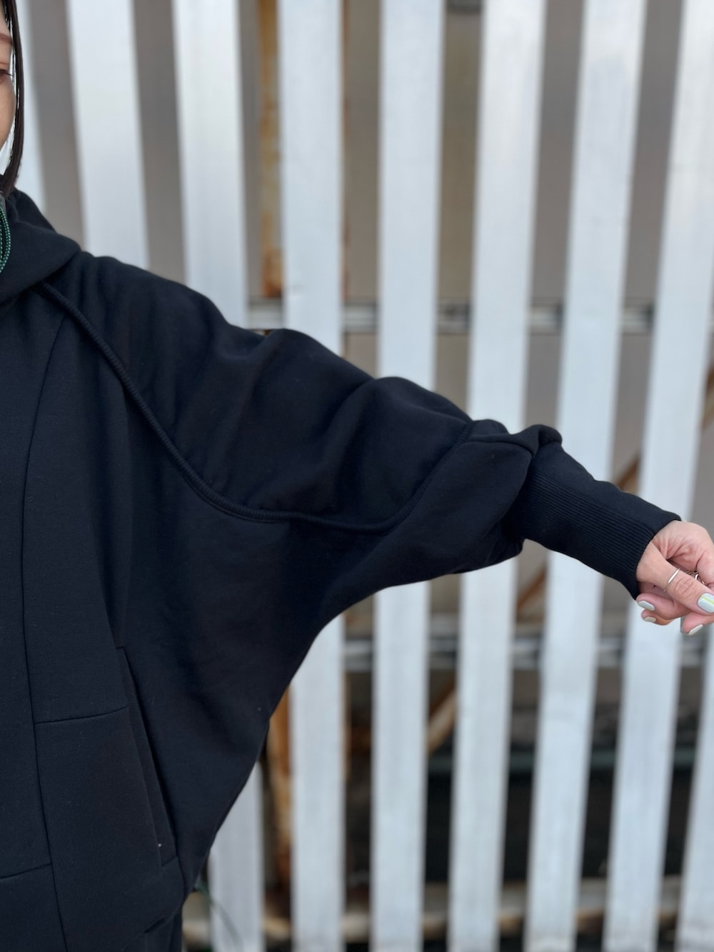 ブラック系のパーカー、ブラック系のスカート、ブラック系のブーツを着用したレディースの冬コーディネートの5枚目の写真