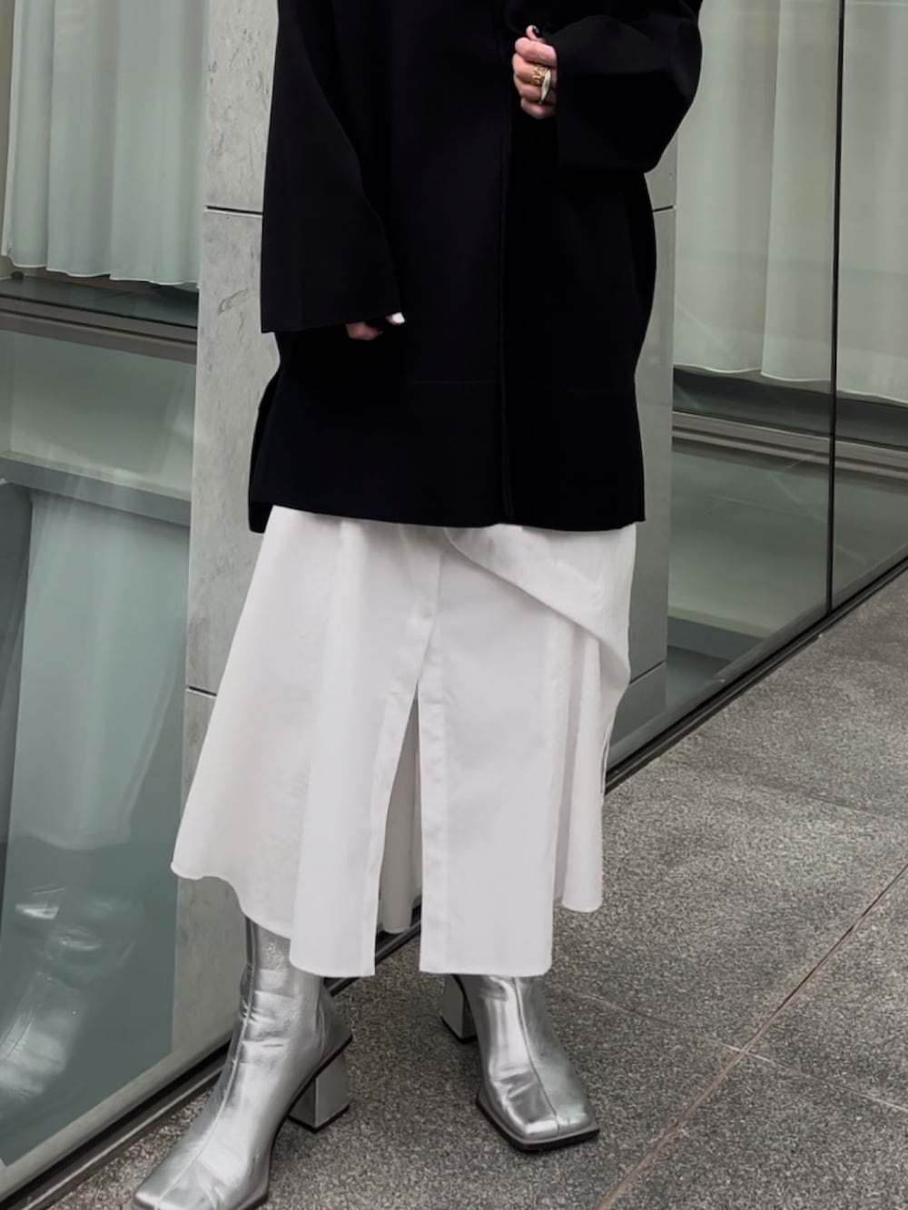 ブラック系のニット/セーター、ホワイト系のワンピース、シルバー系のブーツを着用したレディースの冬コーディネートの5枚目の写真