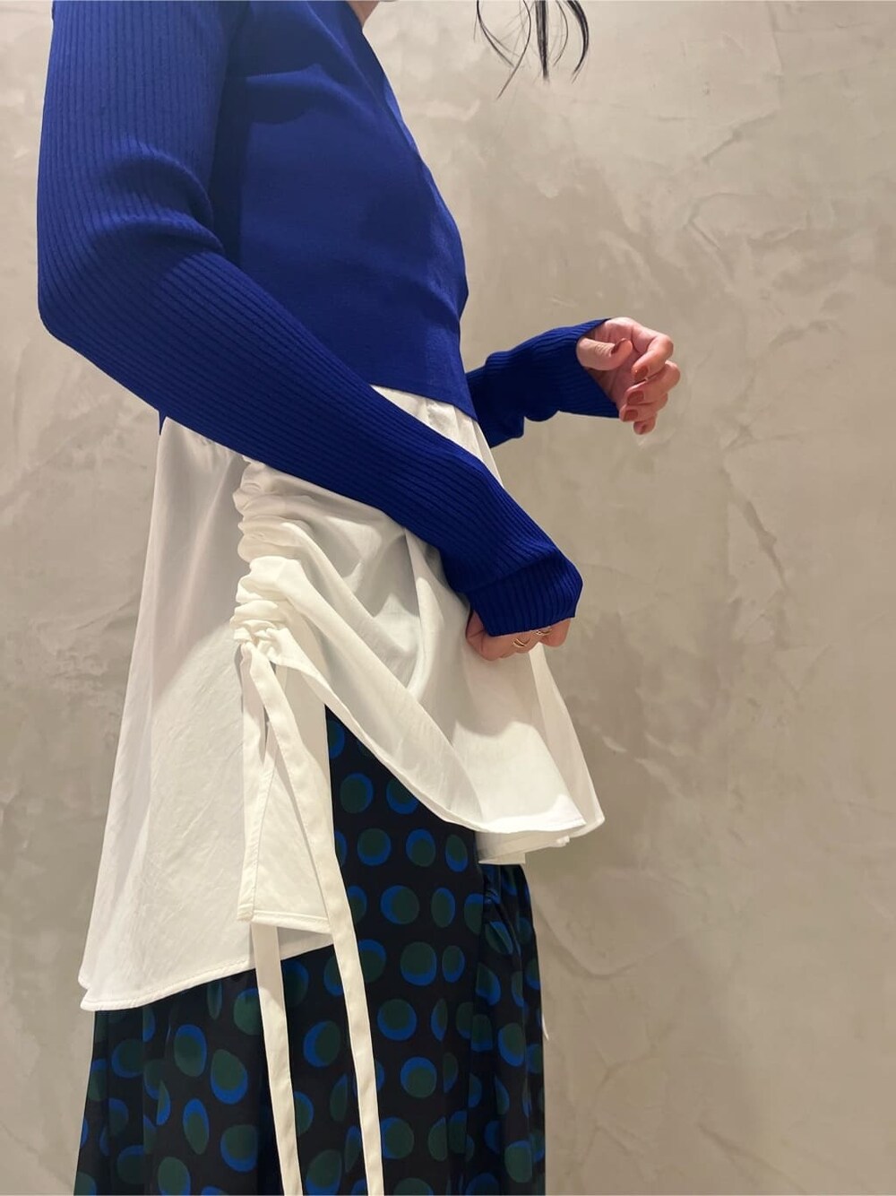 ホワイト系のキャミソール、ブラック系のスカート、ブルー系のニット/セーターを着用したレディースの秋コーディネートの5枚目の写真