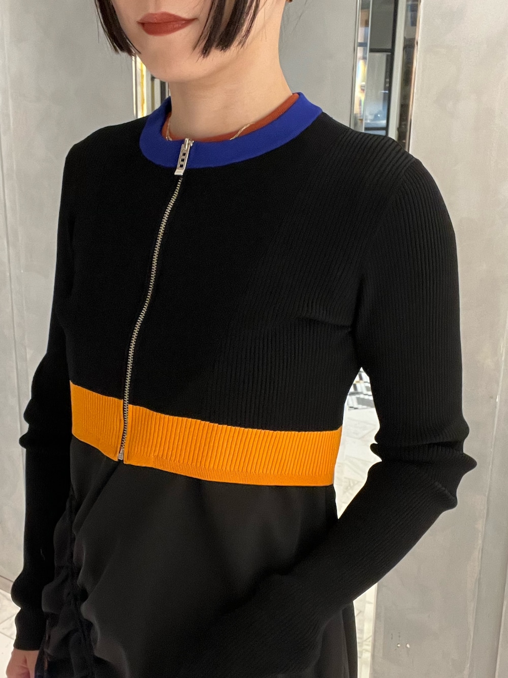 ブラック系のワンピース、ブラウン系のタンクトップ、ブラック系のカーディガン/ボレロを着用したレディースの春コーディネートの2枚目の写真