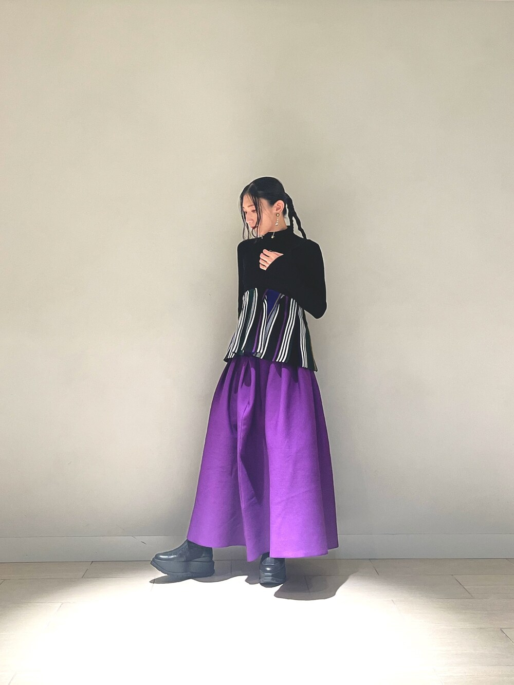 ブラック系のキャミソール、パープル系のスカート、ブラック系のブーツを着用したレディースの冬コーディネートの2枚目の写真