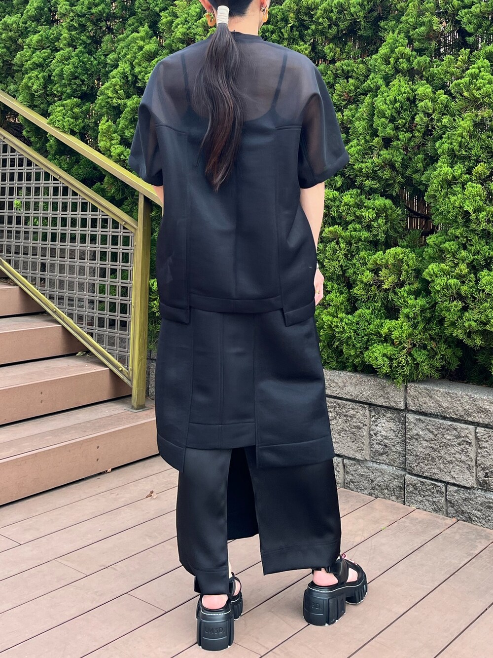 ブラック系のTシャツ/カットソー、ブラック系のスカート、ブラック系のサンダルを着用したレディースの春コーディネートの2枚目の写真