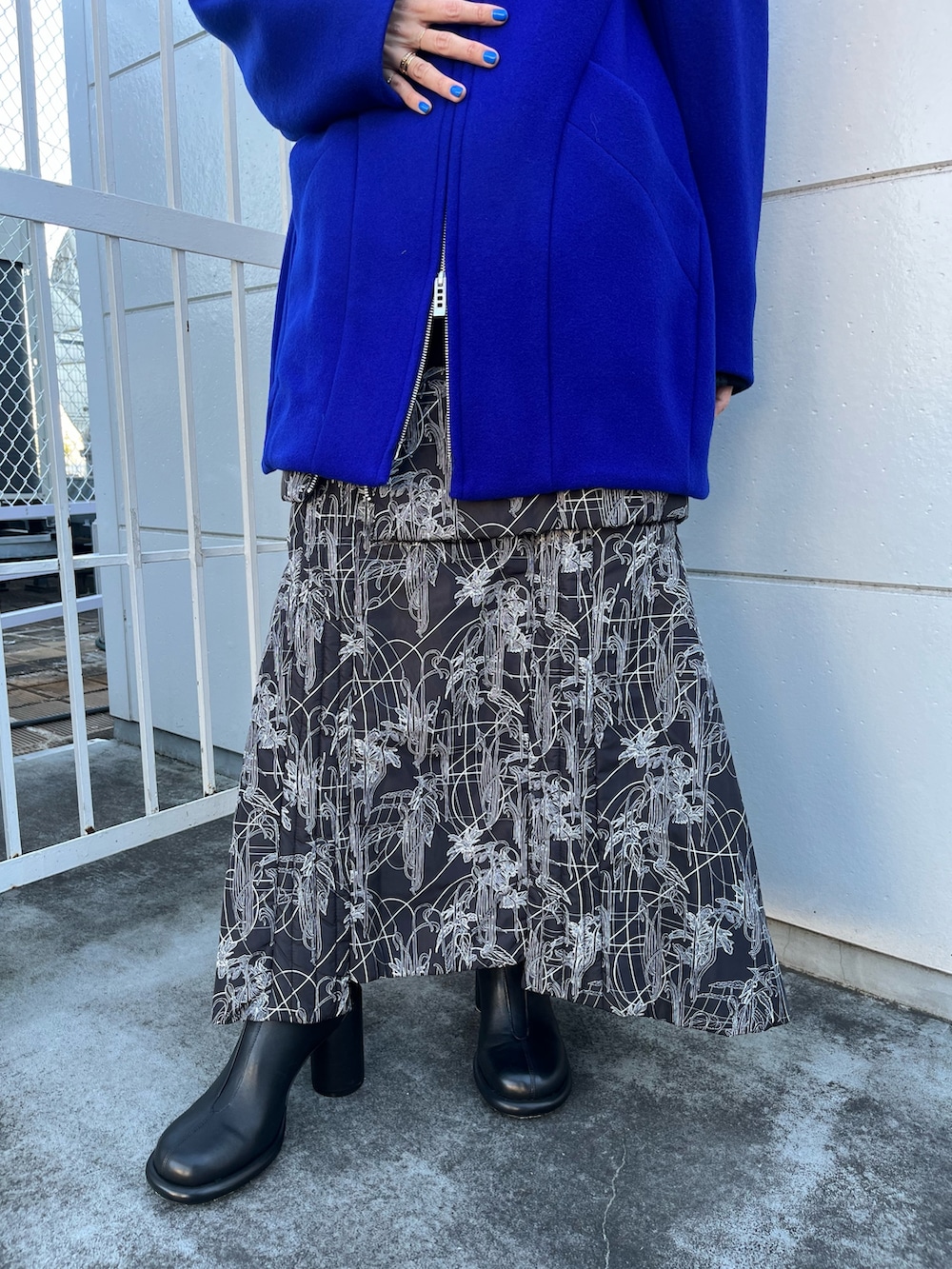 ブルー系のその他アウター、ブラック系のスカート、ブラック系のブーツを着用したレディースの冬コーディネートの8枚目の写真