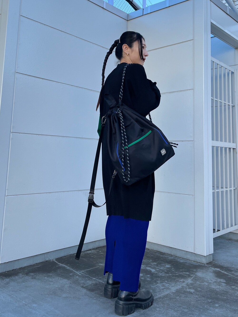 ブラック系のニット/セーター、ブラック系のカーディガン/ボレロ、ブルー系のスカートを着用したレディースの冬コーディネートの4枚目の写真