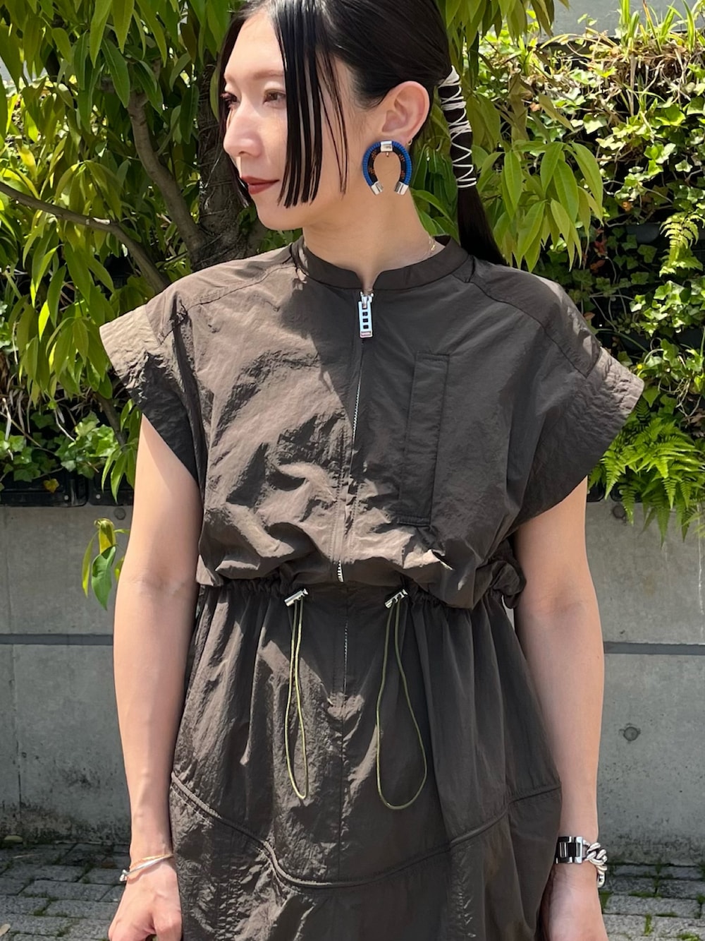 グリーン系のワンピース、ブラック系のサンダル、グレー系のショルダーバッグを着用したレディースの夏コーディネートの4枚目の写真