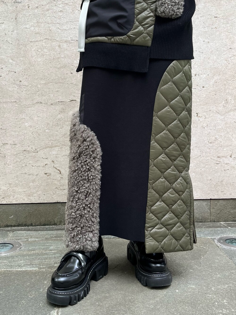 ブラック系のニット/セーター、ブラック系のスカート、ブラック系のローファーを着用したレディースの秋コーディネートの4枚目の写真