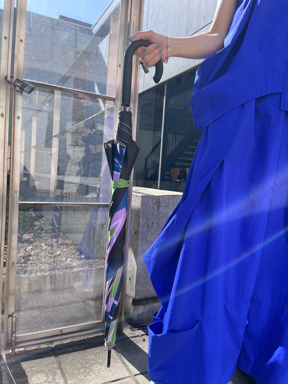 ブルー系のタンクトップ、ブルー系のその他パンツ、ブラック系の長傘を着用したレディースの春コーディネートの6枚目の写真