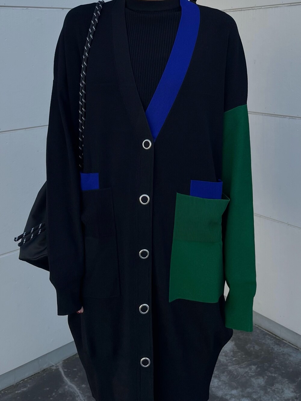 ブラック系のニット/セーター、ブラック系のカーディガン/ボレロ、ブルー系のスカートを着用したレディースの冬コーディネートの5枚目の写真