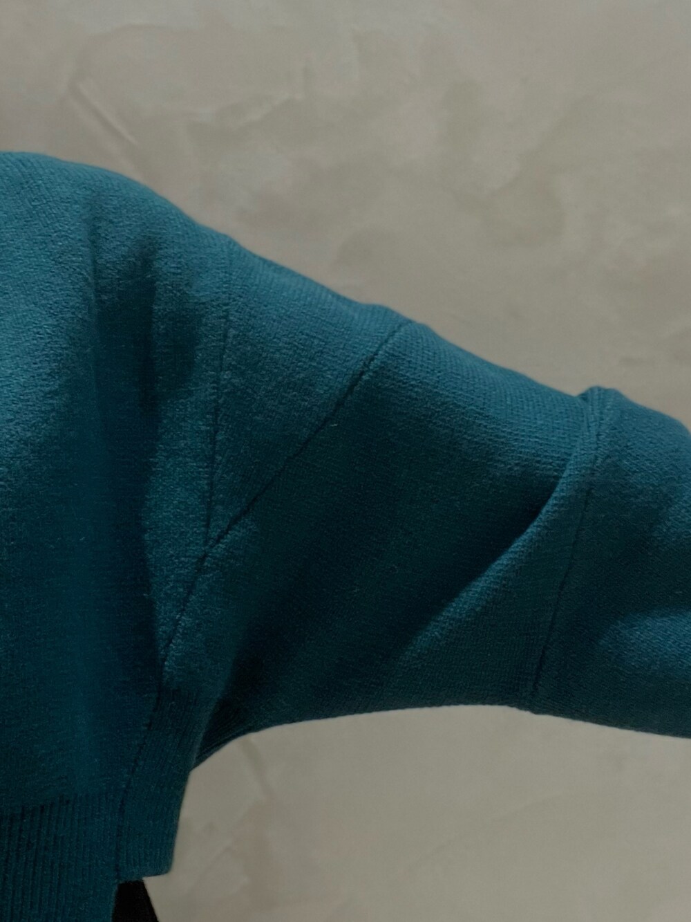 グリーン系のニット/セーター、ブラック系のワンピース、ブラック系のブーツを着用したレディースの秋コーディネートの5枚目の写真