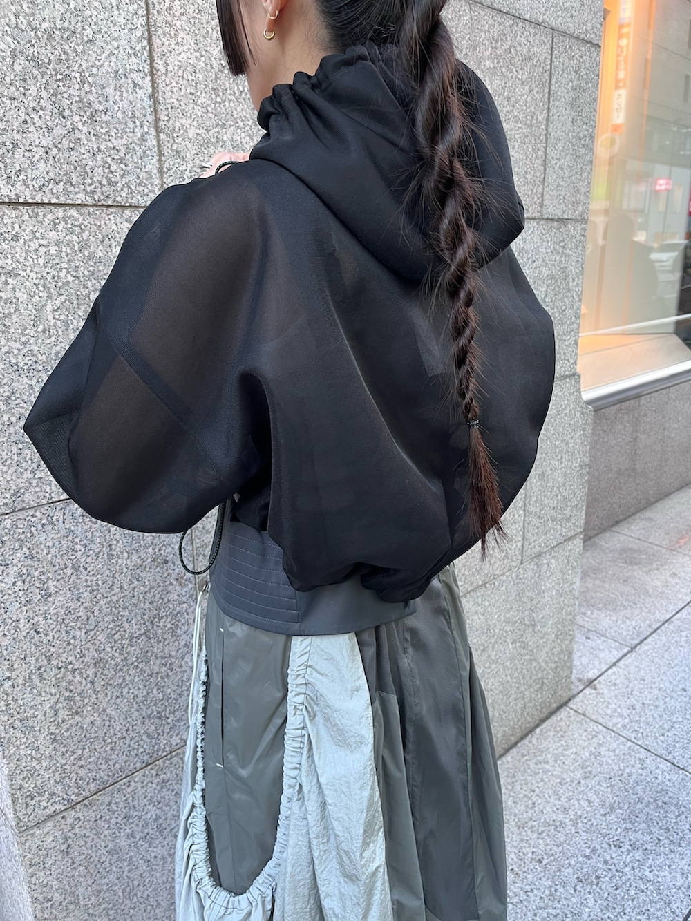 ブラック系のブルゾン、グレー系のタンクトップ、グレー系のジャンパースカートを着用したレディースの春コーディネートの5枚目の写真