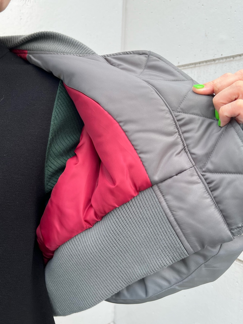 ブラック系のワンピース、グレー系のMA-1、シルバー系のハンドバッグを着用したレディースの冬コーディネートの5枚目の写真