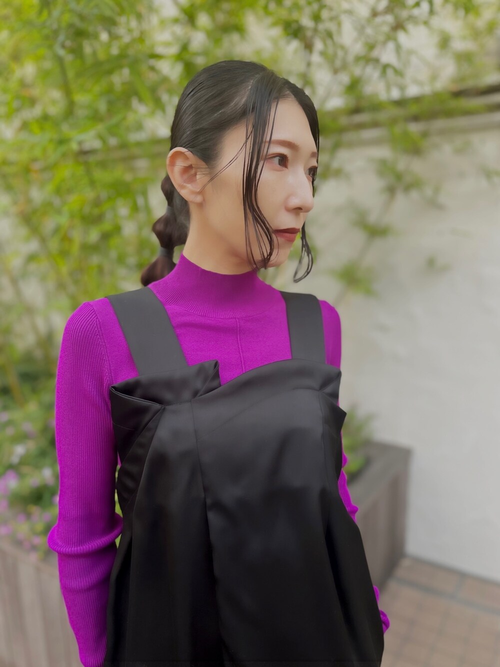 ブラック系のつなぎ/オールインワン、ブラック系のブーツ、パープル系のニット/セーターを着用したレディースの秋コーディネートの3枚目の写真