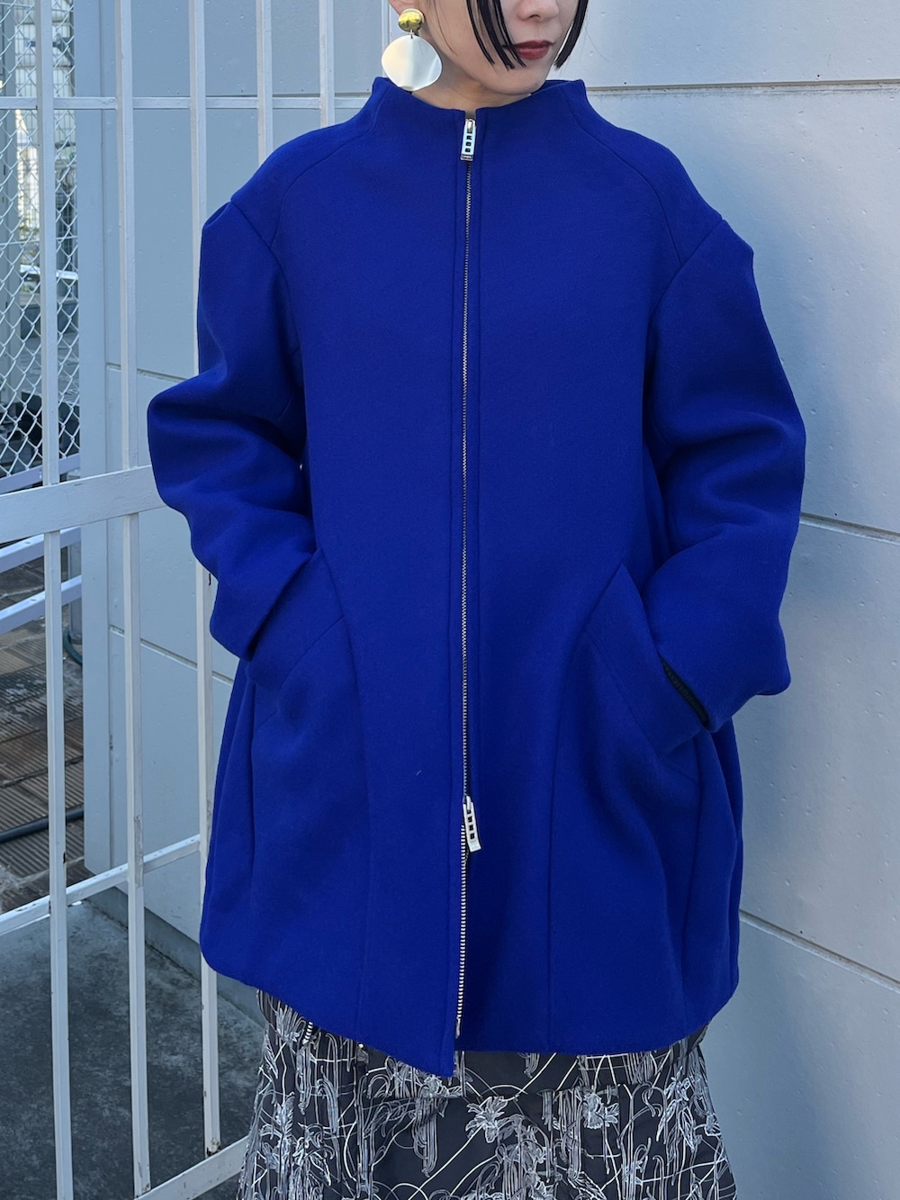 ブルー系のその他アウター、ブラック系のスカート、ブラック系のブーツを着用したレディースの冬コーディネートの4枚目の写真