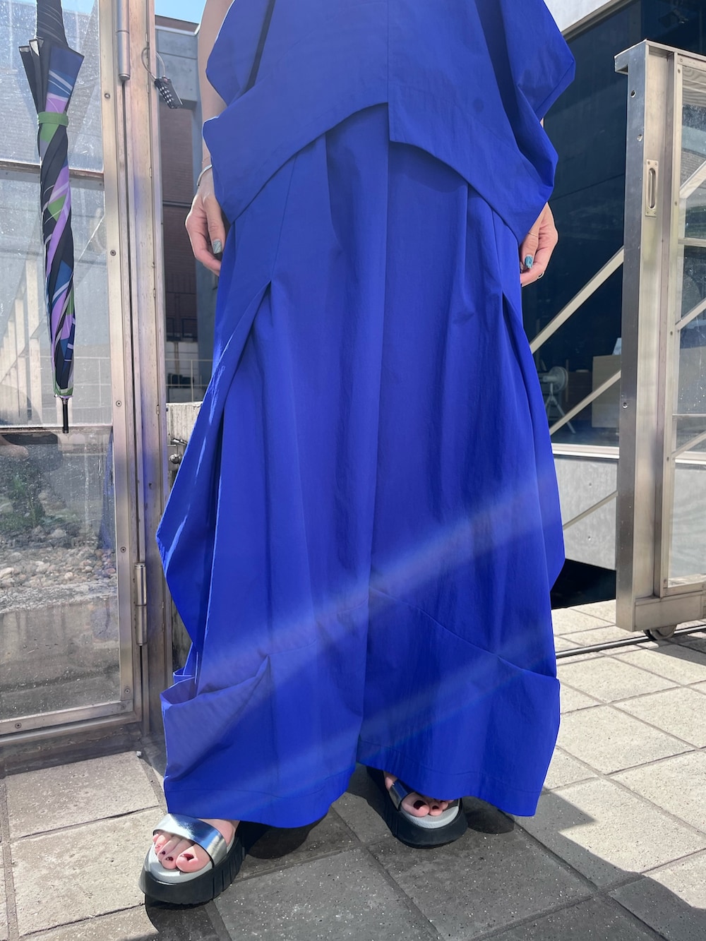 ブルー系のタンクトップ、ブルー系のその他パンツ、ブラック系の長傘を着用したレディースの春コーディネートの5枚目の写真